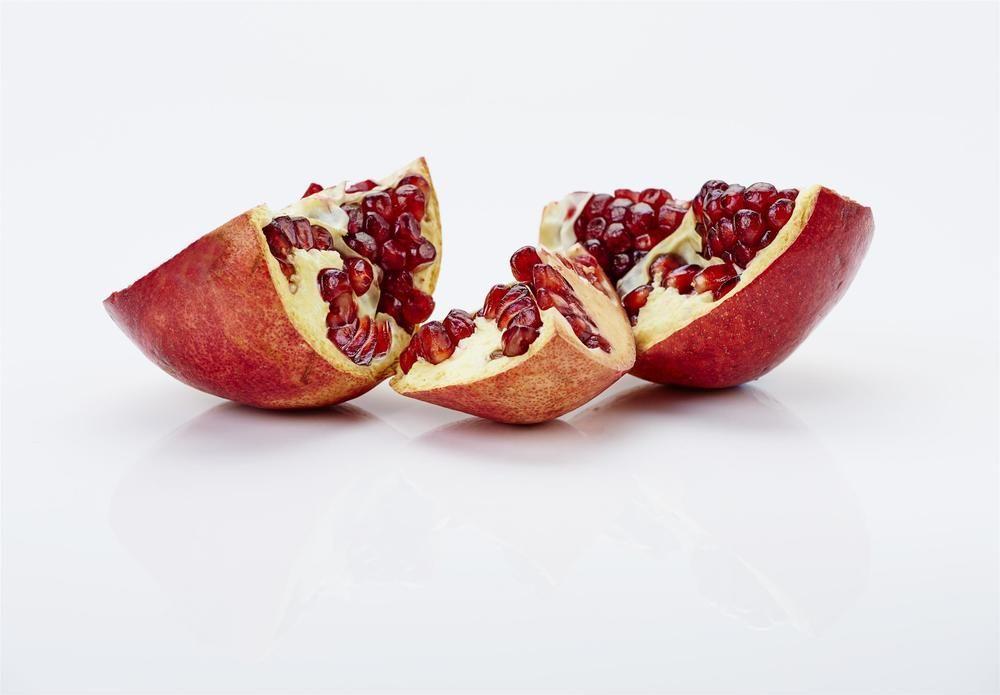 The Fullerton Hotel Sydney Esterno foto The photo shows pomegranate fruit that has been cut into sections. The outer skin is reddish-brown, and the inside reveals juicy, bright red seeds, known as arils. The pieces are arranged on a white surface, highlighting the contrast between the vibr
